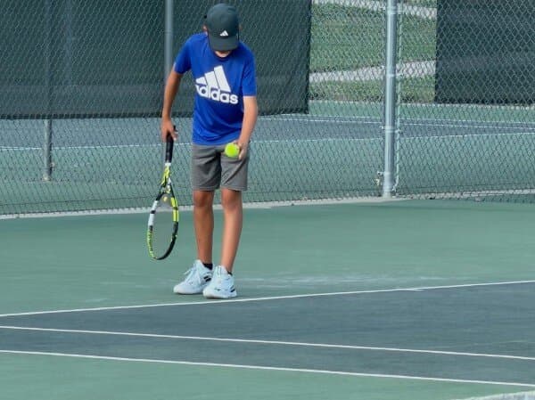 Junior player getting ready to serve