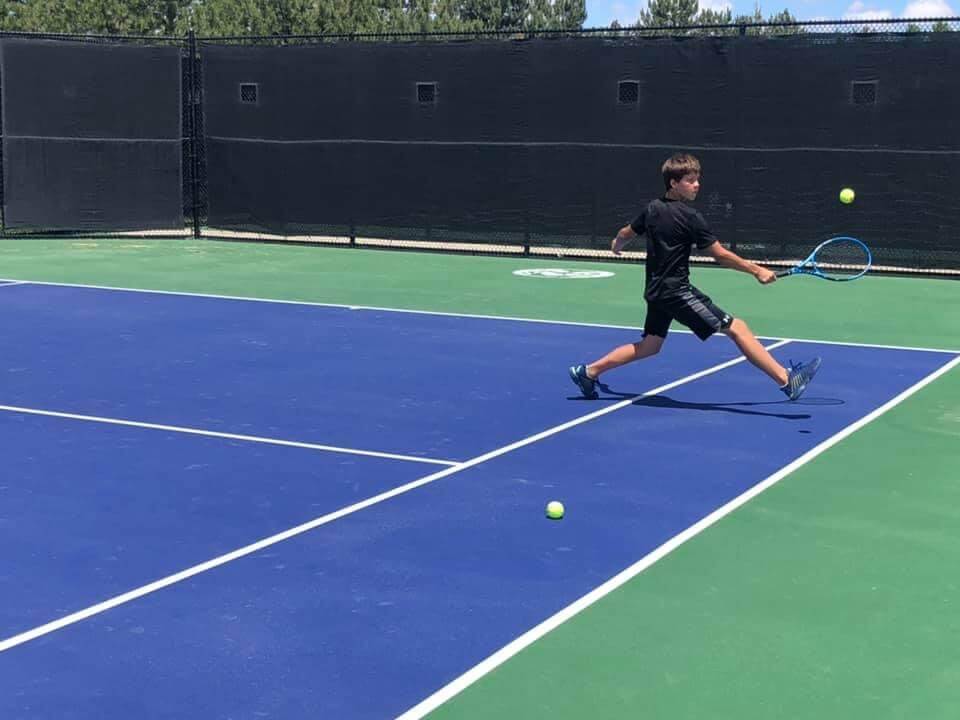 FRA player lunging for a forehand on a blue hard court
