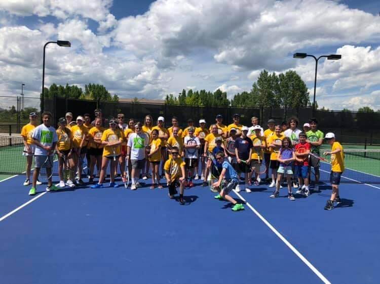 Adidas Tennis Camp players gathered on a blue hard court